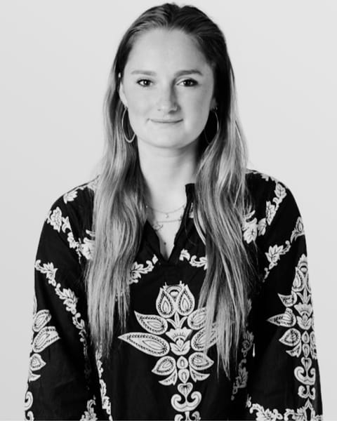 Freya Aylward, in a black and white portrait, with long hair and a patterned top
